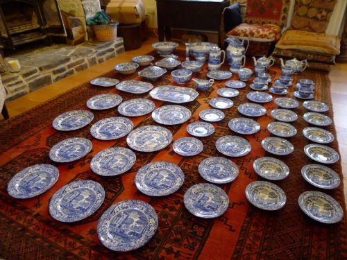 fig 2. An extensive antique Copeland Spode Italian pattern blue and white earthenware dinner service laid out across a red patterned rug.