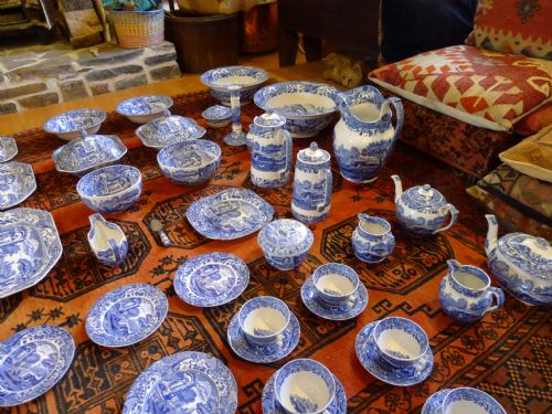 fig 3. An extensive antique Copeland Spode Italian pattern blue and white earthenware dinner service laid out across a red patterned rug.