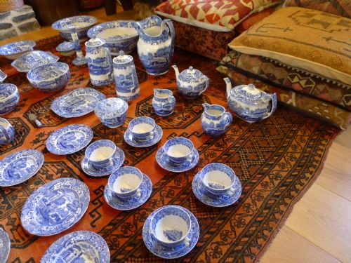 fig 4. An extensive antique Copeland Spode Italian pattern blue and white earthenware dinner service laid out across a red patterned rug.
