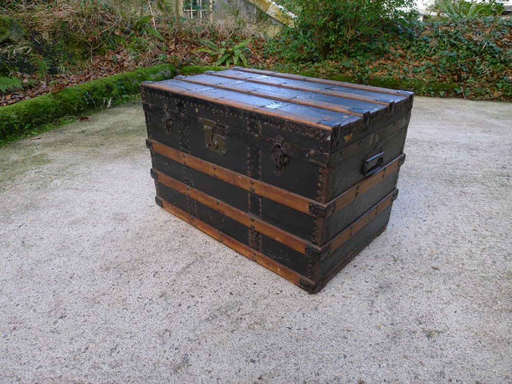 A GOOD WOOD AND BRASS BOUND STEAMER OR CABIN TRUNK ON CASTERS CIRCA 1890