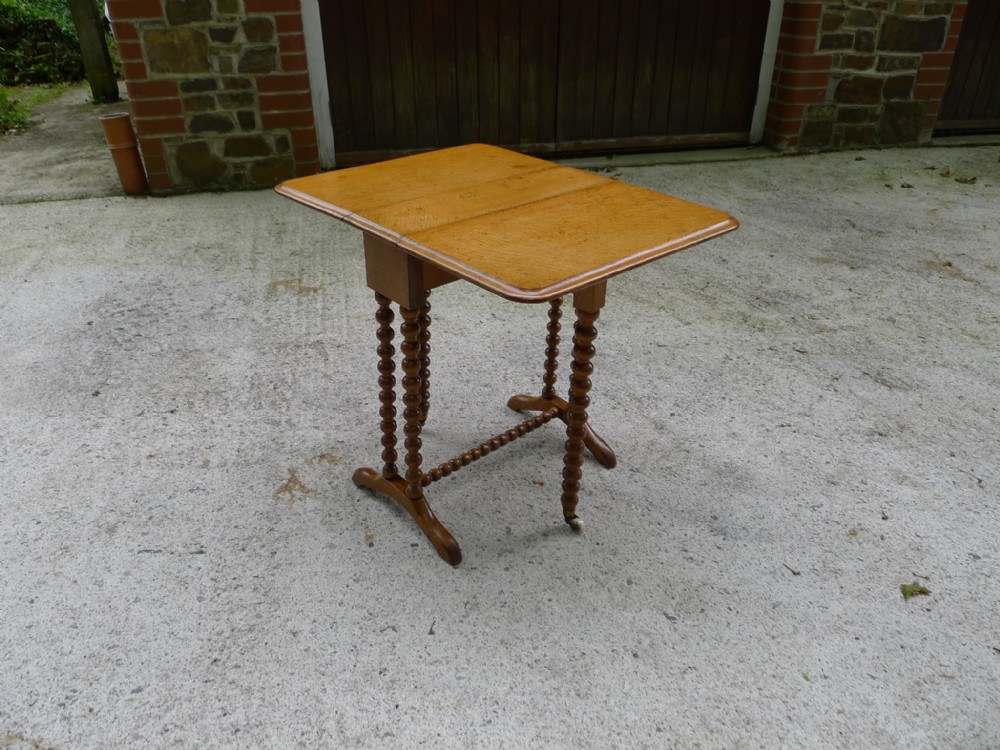 A TINY AND VERY PRETTY VICTORIAN, FIGURED OAK SUTHERLAND TABLE WITH BOBBIN TURNED LEGS AND STRETCHER. CIRCA 1880.