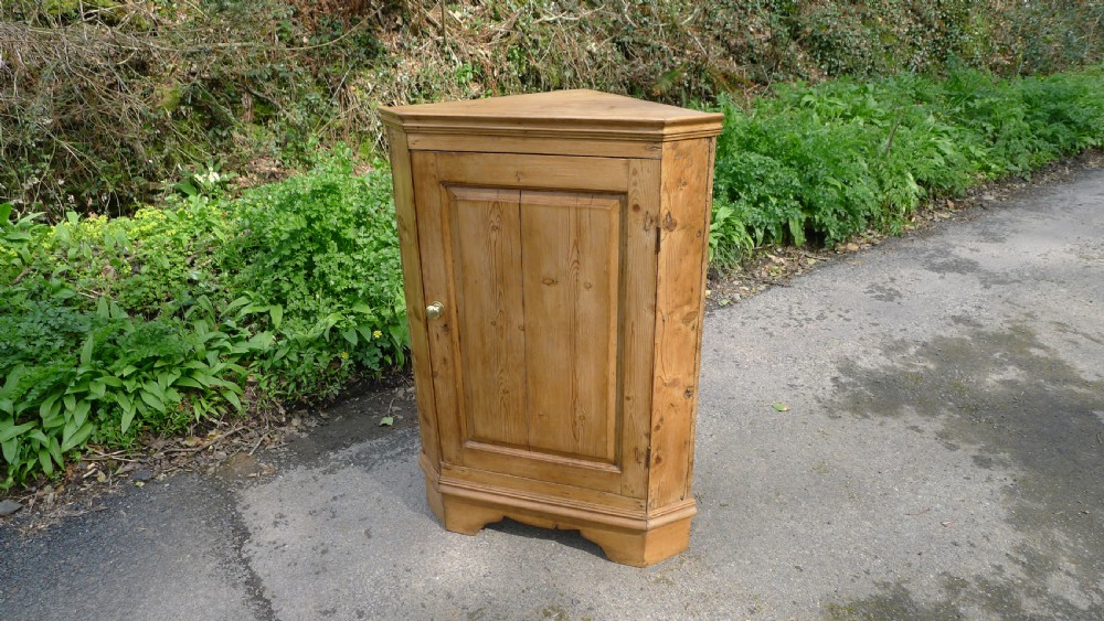 A GOOD COUNTRY PINE CORNER CUPBOARD ON BRACKET FEET. CIRCA 1850 View II