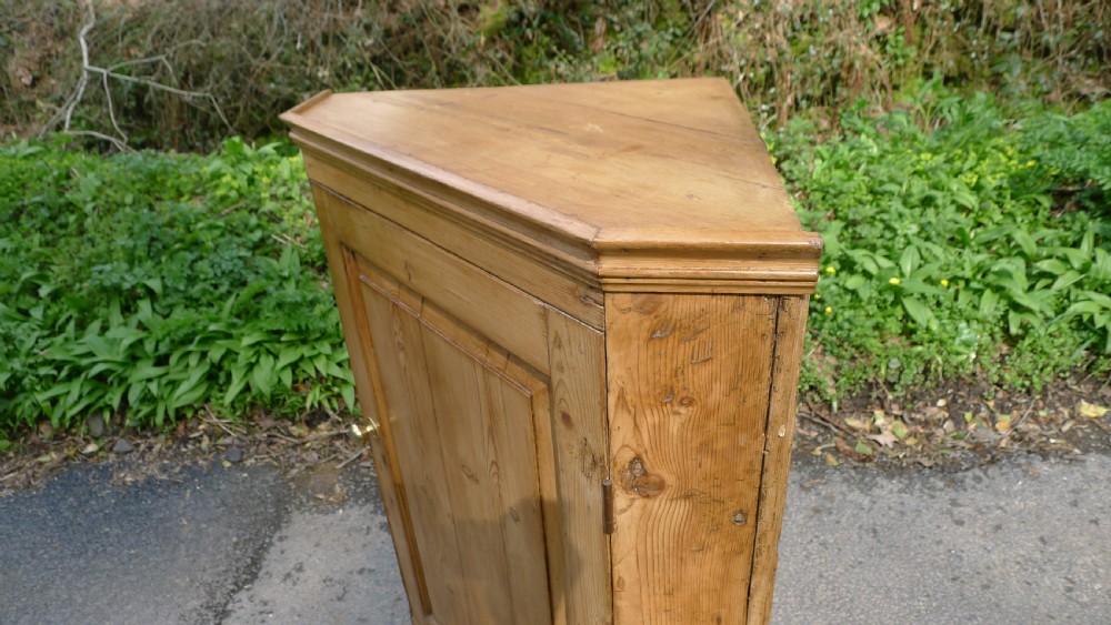A GOOD COUNTRY PINE CORNER CUPBOARD ON BRACKET FEET. CIRCA 1850 View X