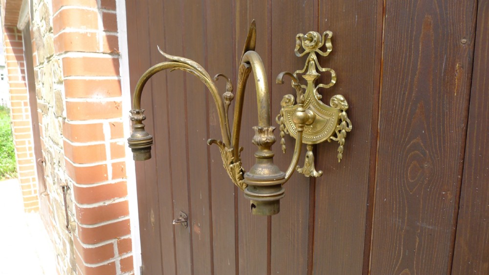 A SUPERB GILDED WALL LIGHT WITH TWIN BRANCH AND RAMS HEAD AND SWAG DECORATION. CIRCA 1900.