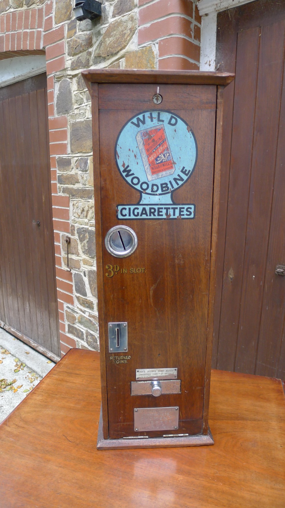 A 'WILD WOODBINE' CIGARETTE VENDING MACHINE IN FULL WORKING ORDER. CIRCA 1930. 3d A PACKET COMPLETE WITH OLD PENNIES! 