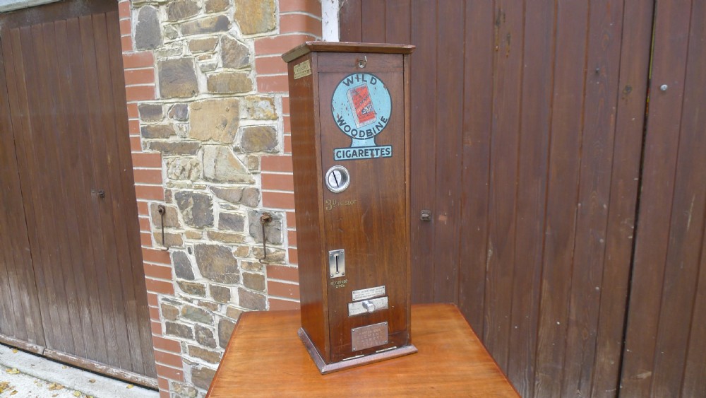 A 'WILD WOODBINE' CIGARETTE VENDING MACHINE IN FULL WORKING ORDER. CIRCA 1930. 3d A PACKET COMPLETE WITH OLD PENNIES!  View II