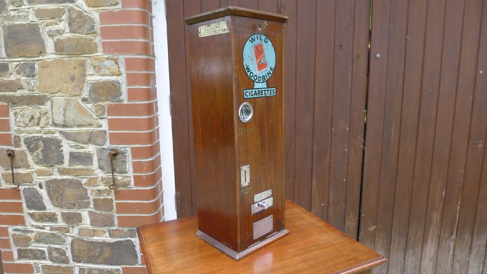 A 'WILD WOODBINE' CIGARETTE VENDING MACHINE IN FULL WORKING ORDER. CIRCA 1930. 3d A PACKET COMPLETE WITH OLD PENNIES!  View III