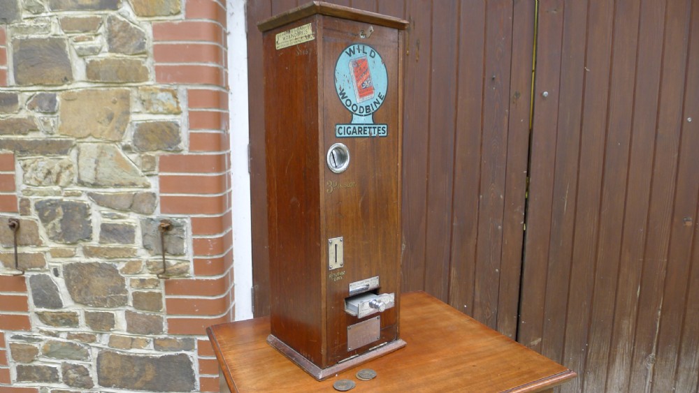 A 'WILD WOODBINE' CIGARETTE VENDING MACHINE IN FULL WORKING ORDER. CIRCA 1930. 3d A PACKET COMPLETE WITH OLD PENNIES!  View XIII
