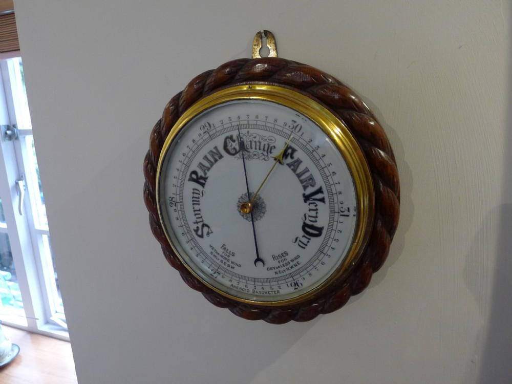 A GOOD OAK CASED ANEROID BAROMETER CIRCA 1890.