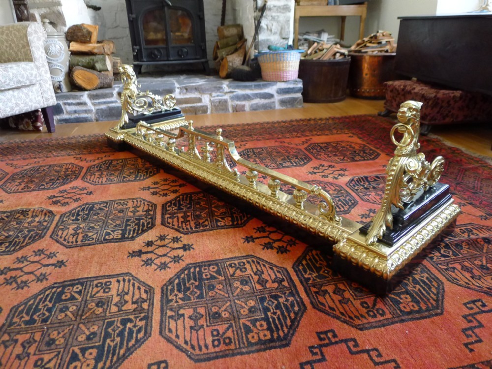 A MAGNIFICANT MID 19th CENTURY BRASS AND IRON FIRE FENDER OR CURB.