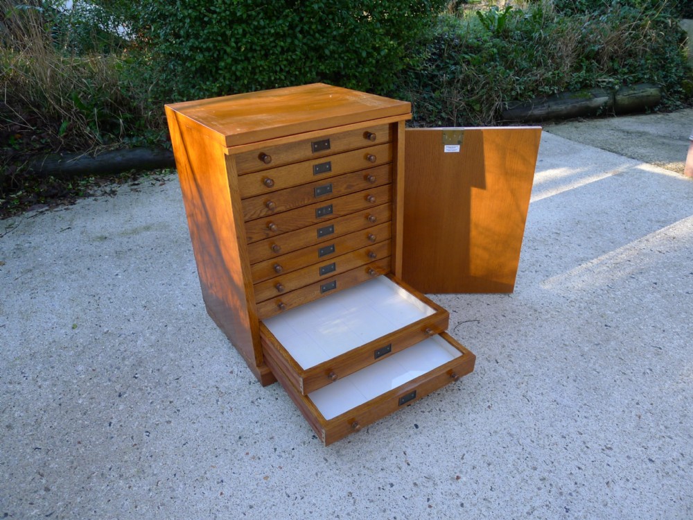 10 DRAWER OAK COLLECTORS CABINET BY GRANGE AND GRIFFITHS. CIRCA 1920.
