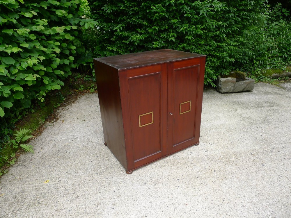 A mid-19th-century stained deal collectors cabinet featuring double doors opened to reveal twenty drawers with brass handles. View II