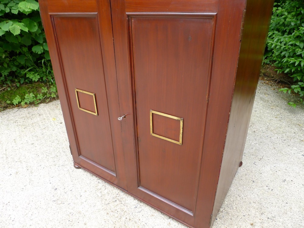 A mid-19th-century stained deal collectors cabinet featuring double doors opened to reveal twenty drawers with brass handles. View V