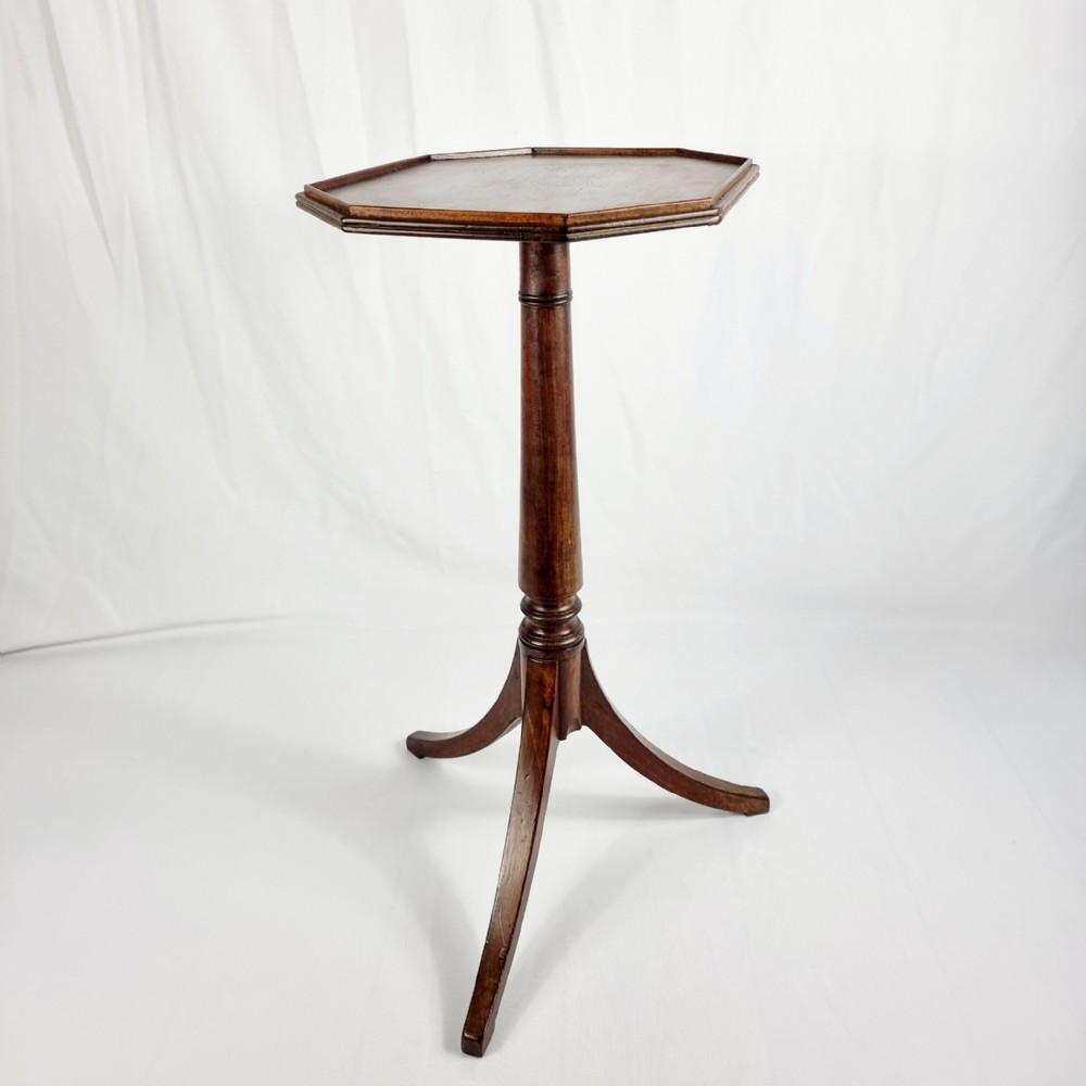 A Regency style mahogany wine table featuring a hexagonal top with a moulded rim, supported by a turned pedestal column and tripod legs.