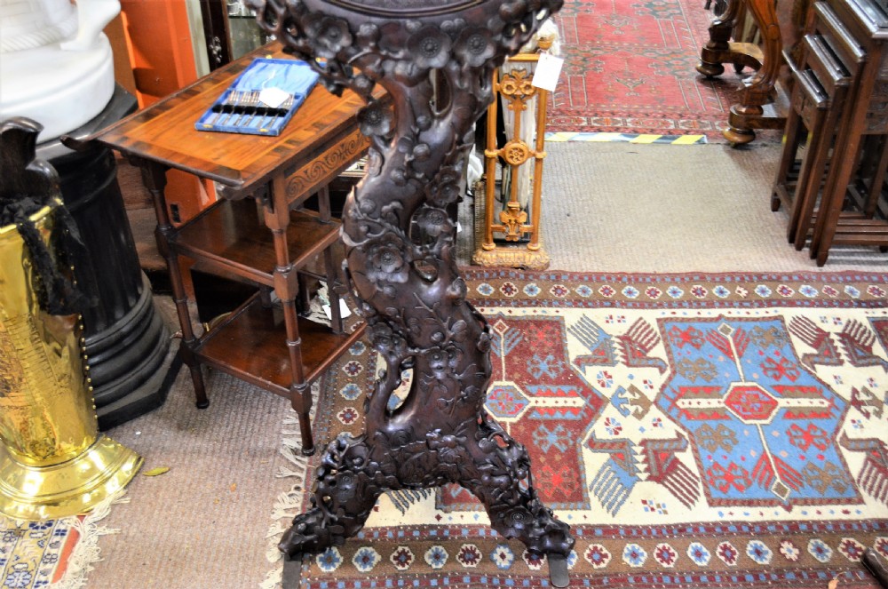 A 19th-century Chinese freestanding mirror featuring a circular glass face enclosed in a dark cherrywood frame carved with naturalistic prunus blossom branches. View VII