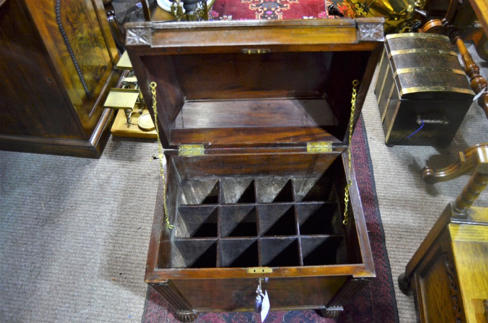 A Regency mahogany wine cooler featuring a sarcophagus shape, fluted corner pilasters, carved rosettes, a brass keyhole escutcheon, and gadrooned feet. View III