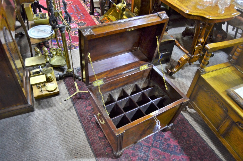 A Regency mahogany wine cooler featuring a sarcophagus shape, fluted corner pilasters, carved rosettes, a brass keyhole escutcheon, and gadrooned feet. View IV