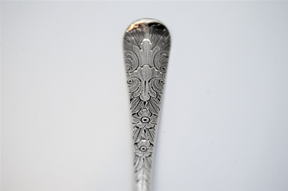 A pair of 18th-century Irish sterling silver spoons featuring embossed fruit and leaf designs in the bowls and chased pattern handles. View III