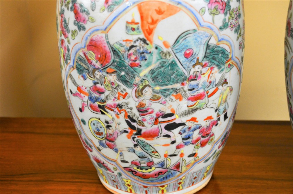 A pair of 19th-century Chinese Famille Rose porcelain baluster vases decorated with hand-painted narrative scenes inside cartouches and yellow pierced handles. View II