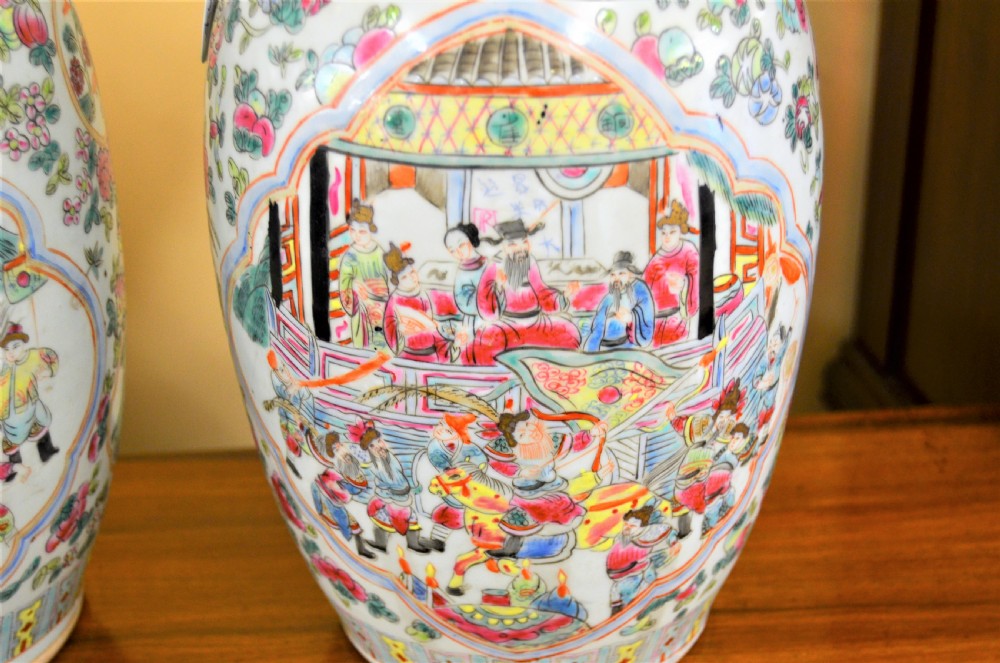 A pair of 19th-century Chinese Famille Rose porcelain baluster vases decorated with hand-painted narrative scenes inside cartouches and yellow pierced handles. View III