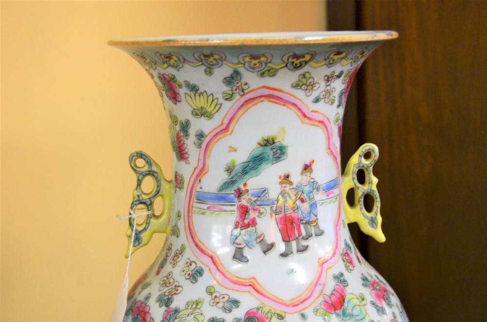 A pair of 19th-century Chinese Famille Rose porcelain baluster vases decorated with hand-painted narrative scenes inside cartouches and yellow pierced handles. View IV