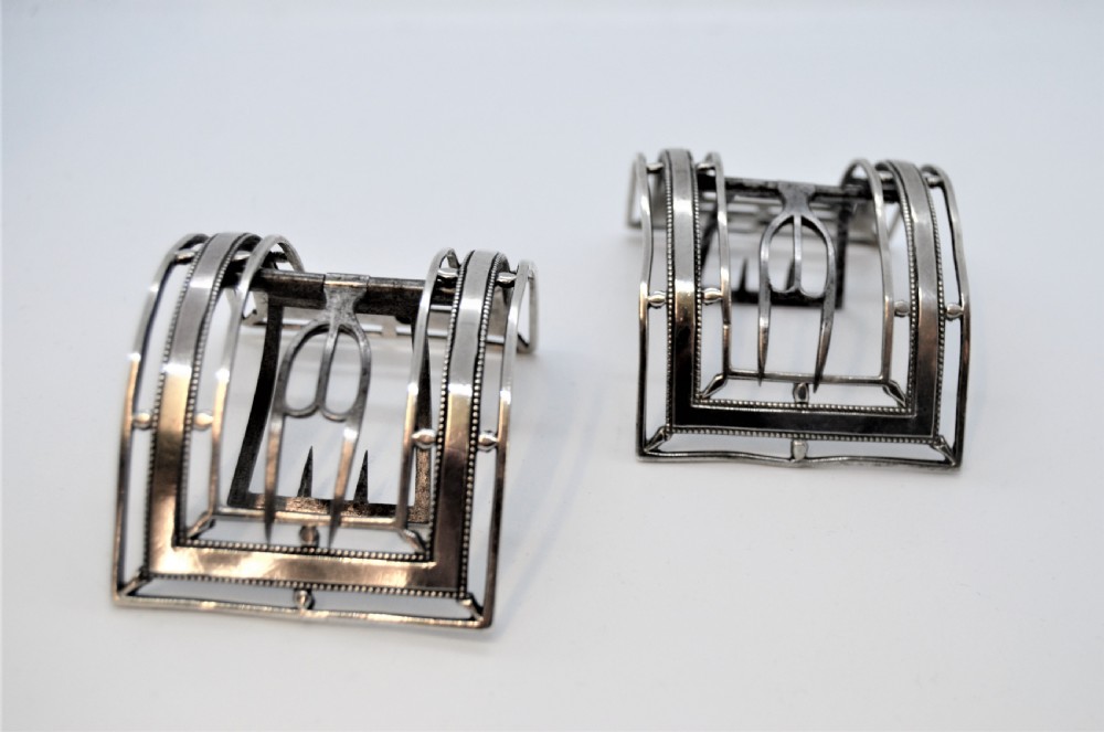 A pair of curved antique Irish silver shoe buckles with beaded borders and steel prongs.