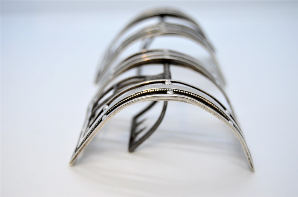 A pair of curved antique Irish silver shoe buckles with beaded borders and steel prongs. View III