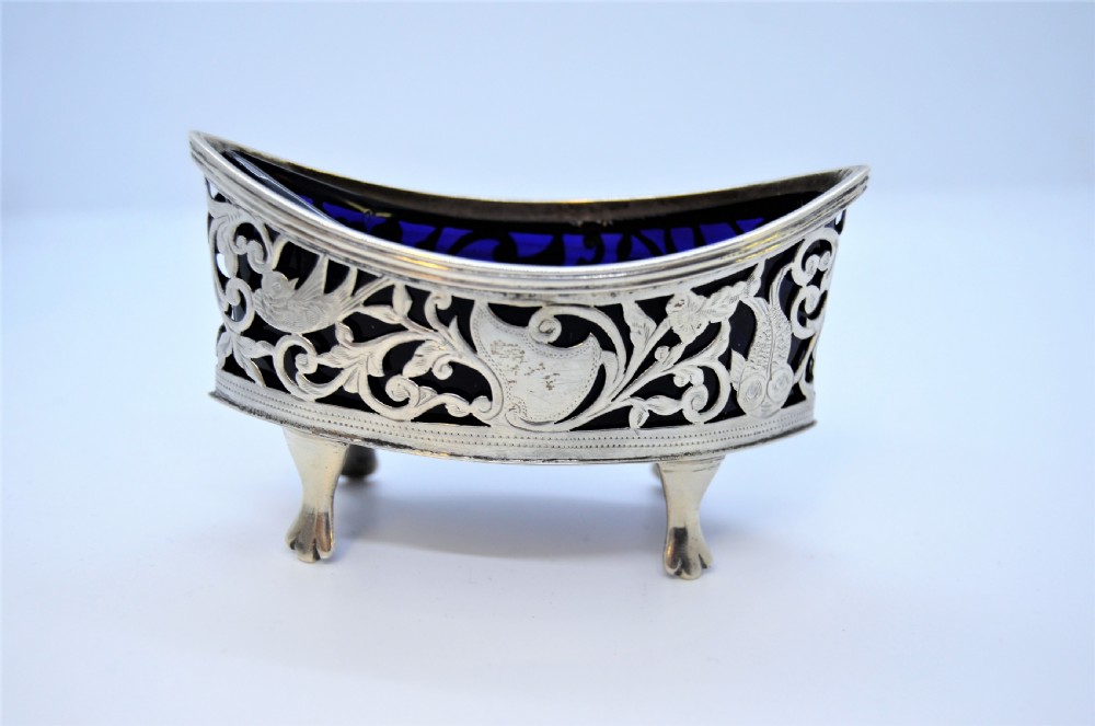 A pair of pierced silver open salt cellars raised on claw feet and fitted with deep cobalt blue glass liners. View II