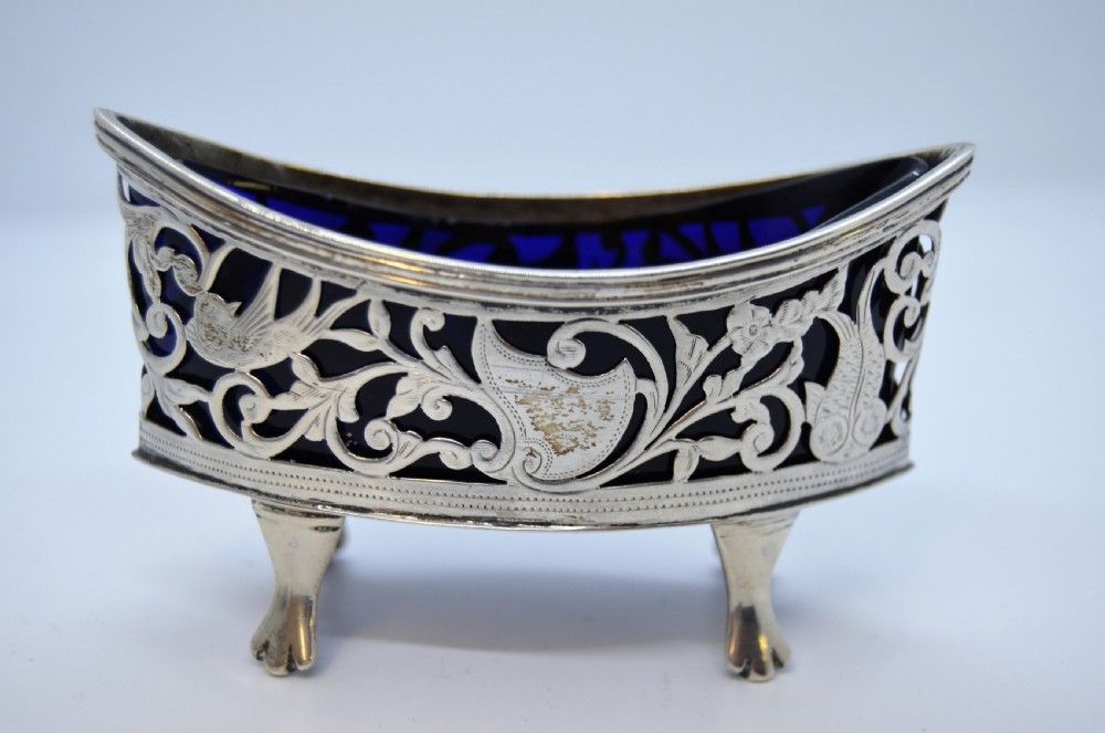 A pair of pierced silver open salt cellars raised on claw feet and fitted with deep cobalt blue glass liners. View IV