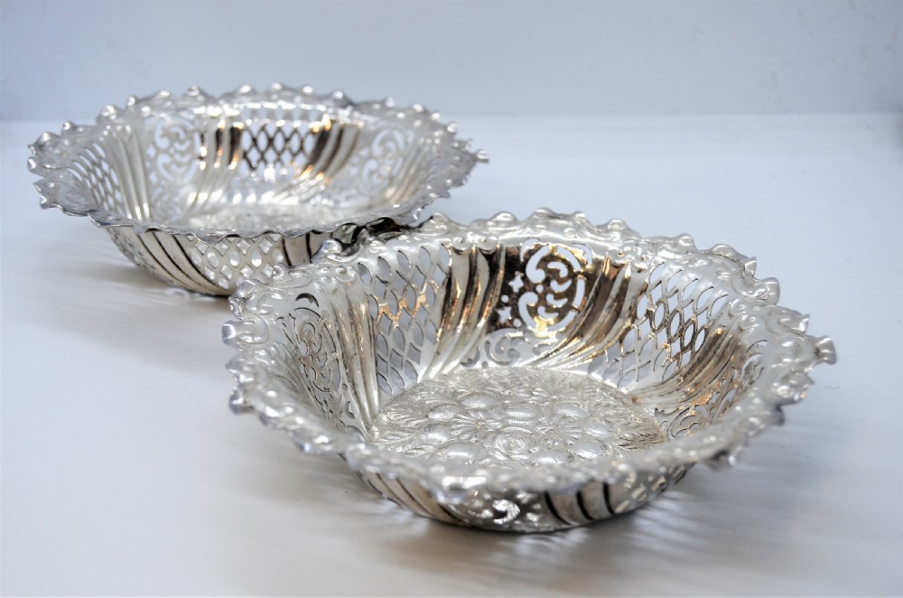 A round Victorian silver dish featuring a pierced lattice pattern, scalloped rim, and embossed floral center motif. View II