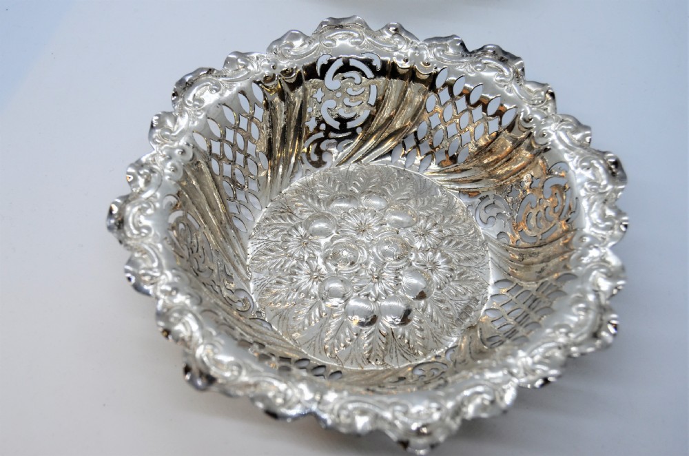 A round Victorian silver dish featuring a pierced lattice pattern, scalloped rim, and embossed floral center motif. View III