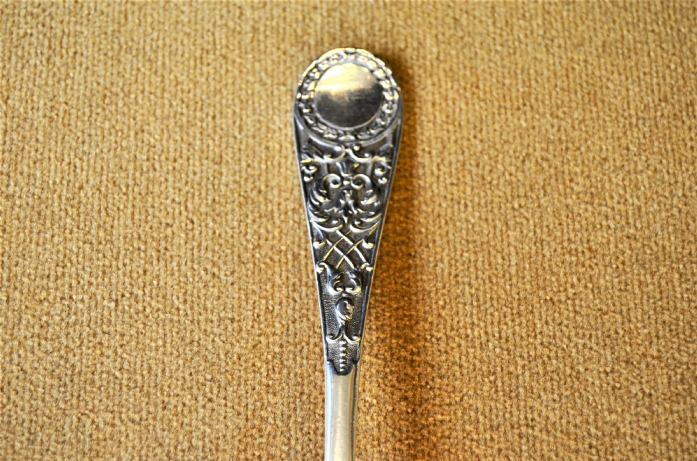A pair of silver serving spoons featuring detailed fruit engraving in the bowls and decorative handles. View II