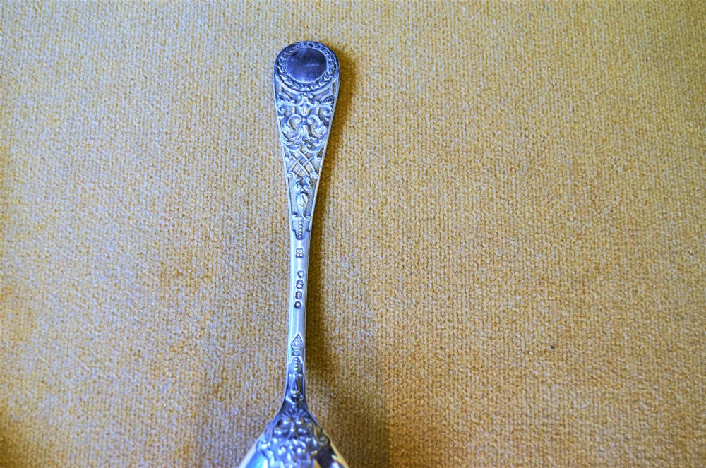 A pair of silver serving spoons featuring detailed fruit engraving in the bowls and decorative handles. View IV