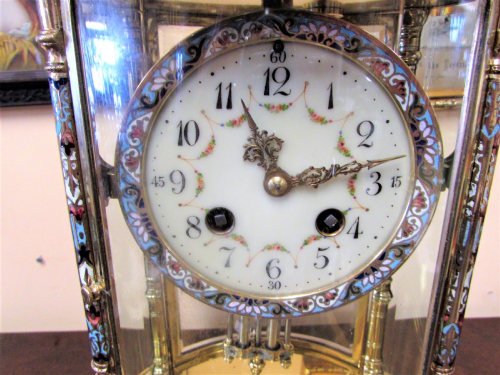 An oval Victorian brass four glass mantel clock featuring colourful cloisonne enamel floral borders and a porcelain dial. View IV