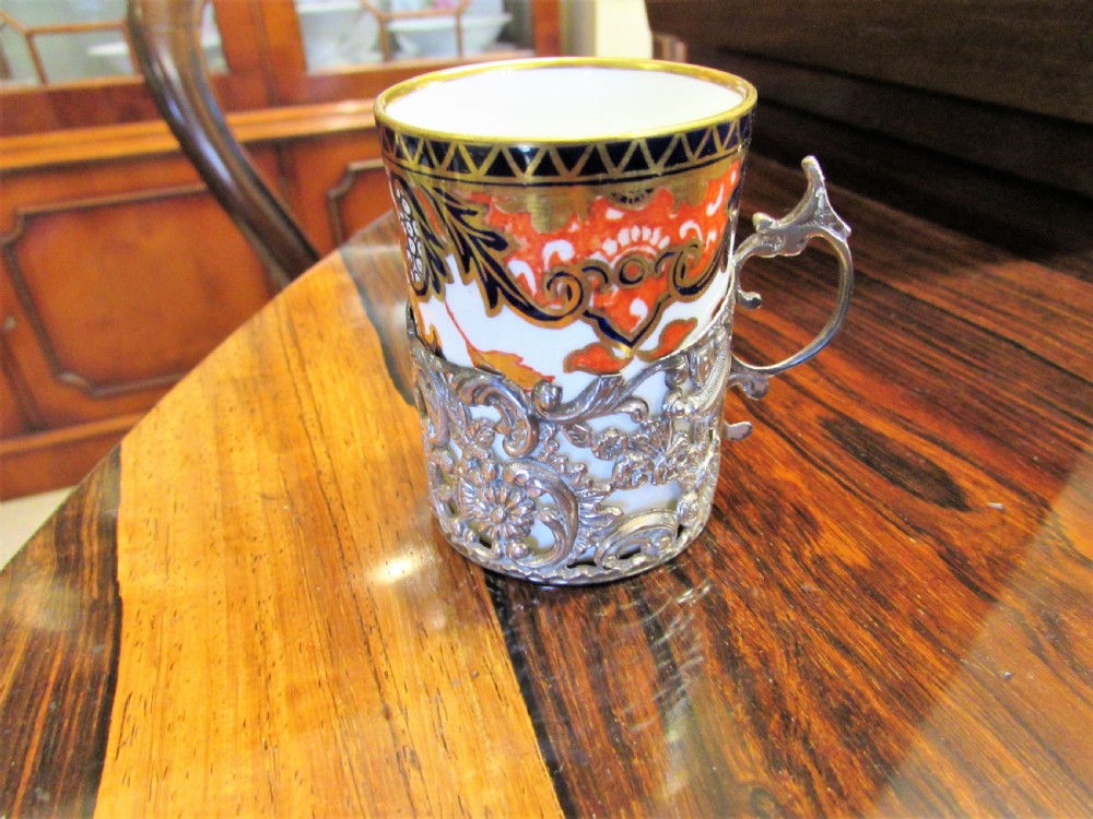 A cased set of Royal Crown Derby porcelain demitasse coffee cups with pierced silver holders and matching saucers in a satin-lined presentation box. View IV