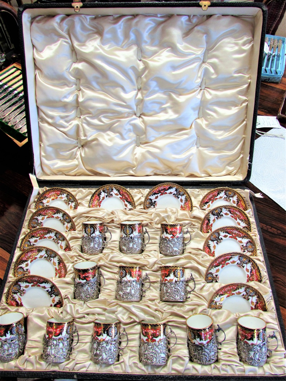 A cased set of Royal Crown Derby porcelain demitasse coffee cups with pierced silver holders and matching saucers in a satin-lined presentation box. View V