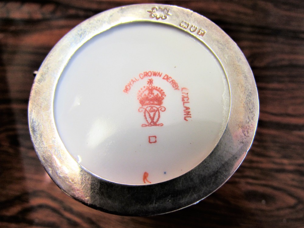 A cased set of Royal Crown Derby porcelain demitasse coffee cups with pierced silver holders and matching saucers in a satin-lined presentation box. View VI