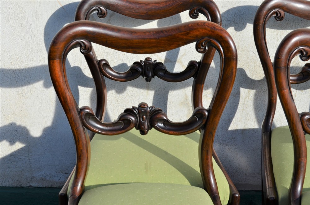 A set of six Victorian rosewood balloon-back dining chairs featuring carved cross-rails, turned front legs, and light green upholstered seats. View III