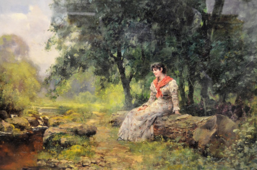 A Victorian oil painting depicting a woman seated beside a stream in a forested landscape, enclosed within an ornate carved gilt frame. View II