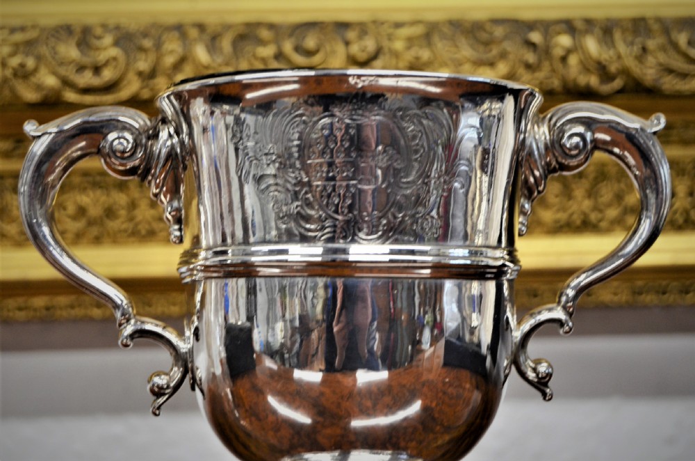 An 18th-century silver two-handled cup featuring an engraved crest, double-scroll handles, a central moulding, and a circular pedestal foot. View II
