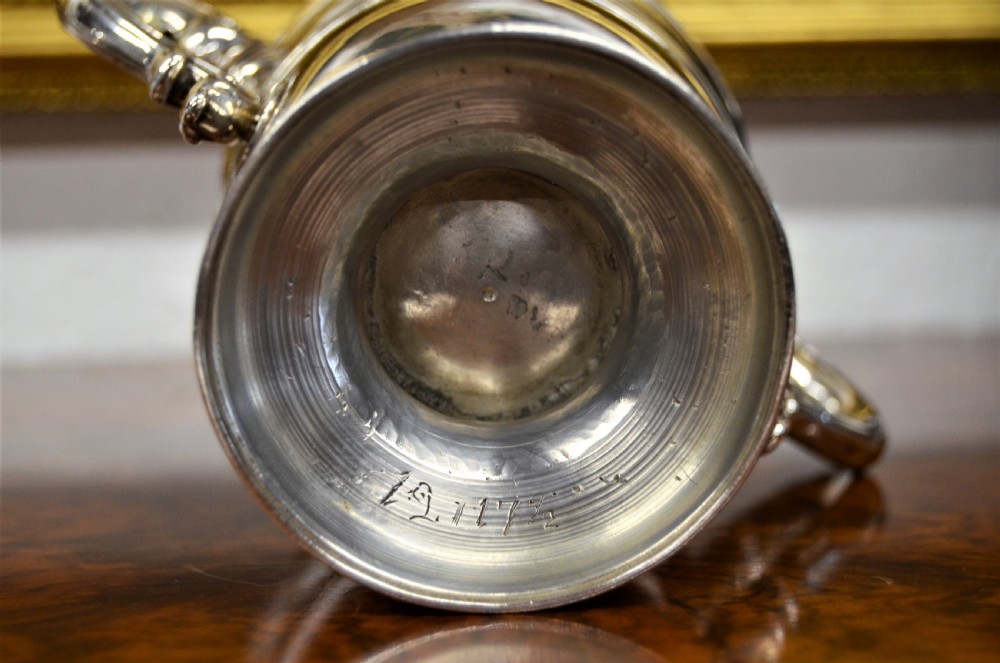 An 18th-century silver two-handled cup featuring an engraved crest, double-scroll handles, a central moulding, and a circular pedestal foot. View VI