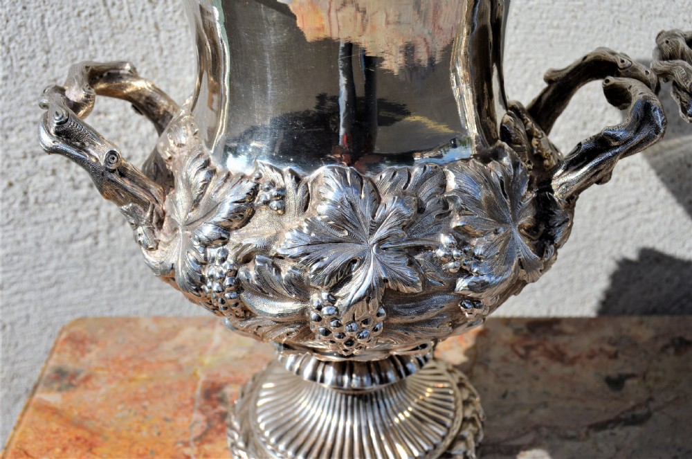 A pair of silver twin-handled urn-shaped vases featuring raised grapevine ornamentation, branch-form handles, and fluted pedestal bases. View II