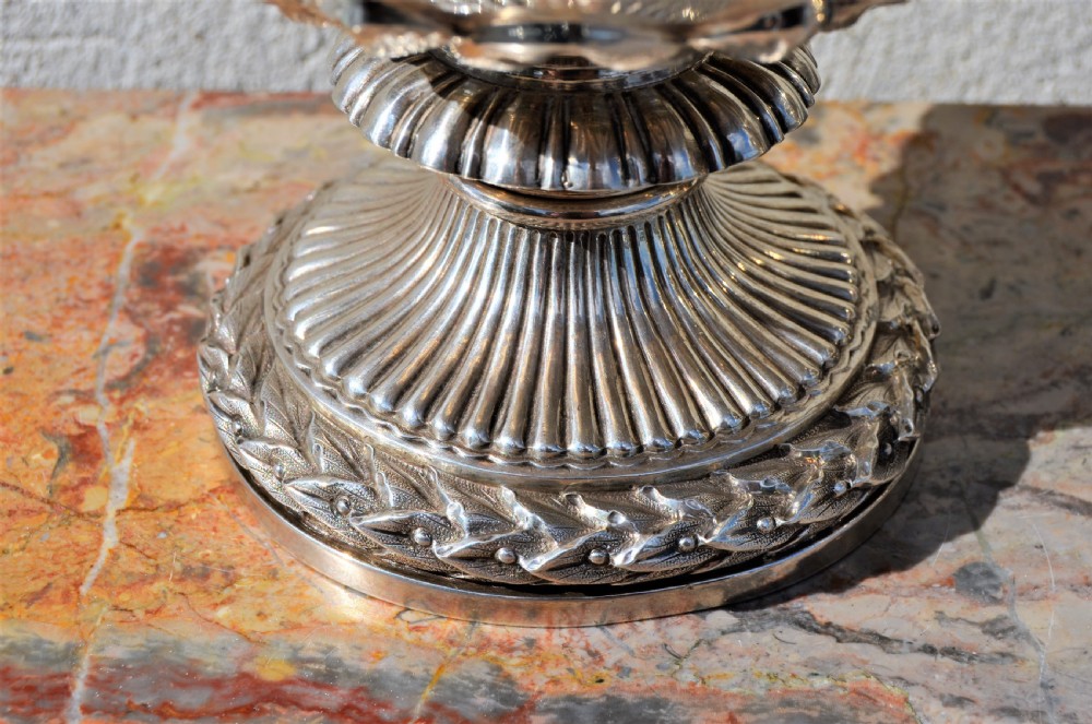 A pair of silver twin-handled urn-shaped vases featuring raised grapevine ornamentation, branch-form handles, and fluted pedestal bases. View IV