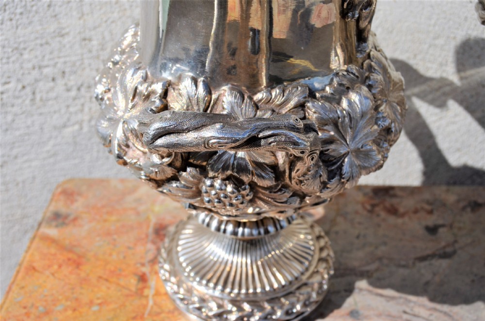 A pair of silver twin-handled urn-shaped vases featuring raised grapevine ornamentation, branch-form handles, and fluted pedestal bases. View V