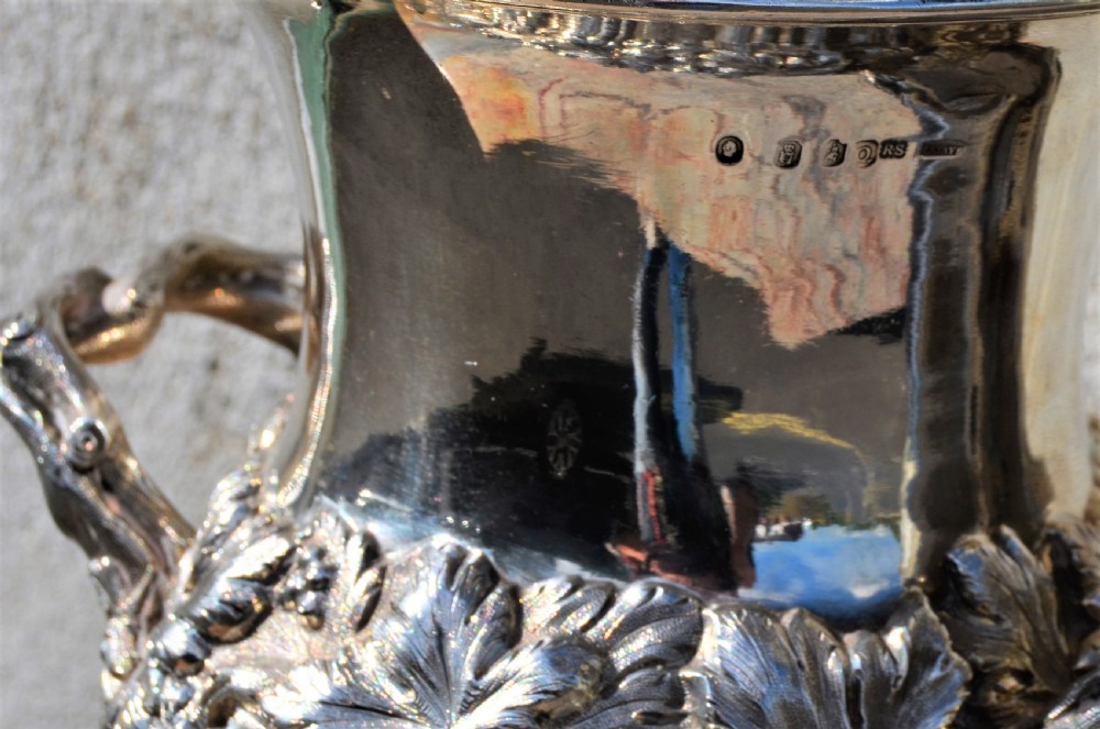 A pair of silver twin-handled urn-shaped vases featuring raised grapevine ornamentation, branch-form handles, and fluted pedestal bases. View VII