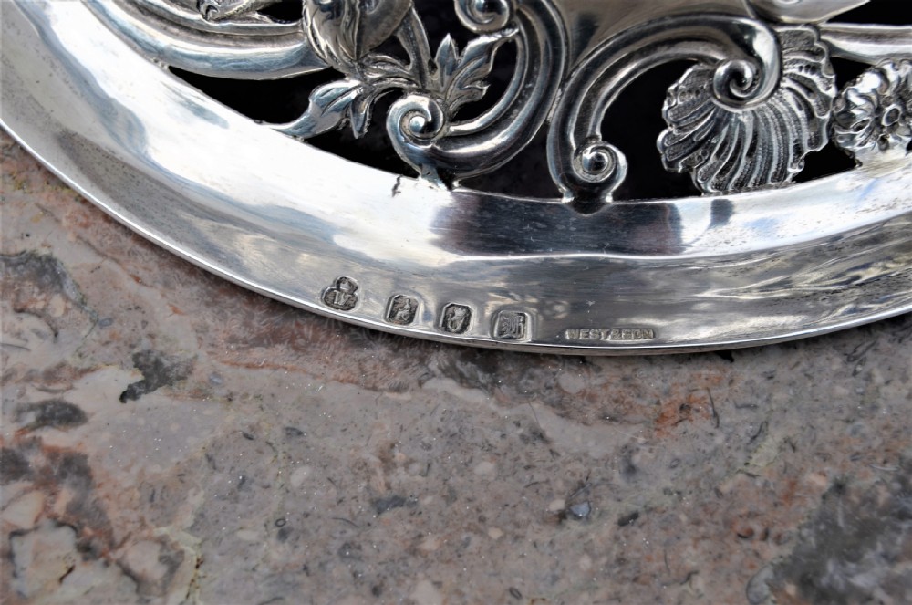 A pierced sterling silver Irish dish ring decorated with repousse animals, scrolls, and an engraved coat of arms, complete with a cobalt blue glass liner. View IV