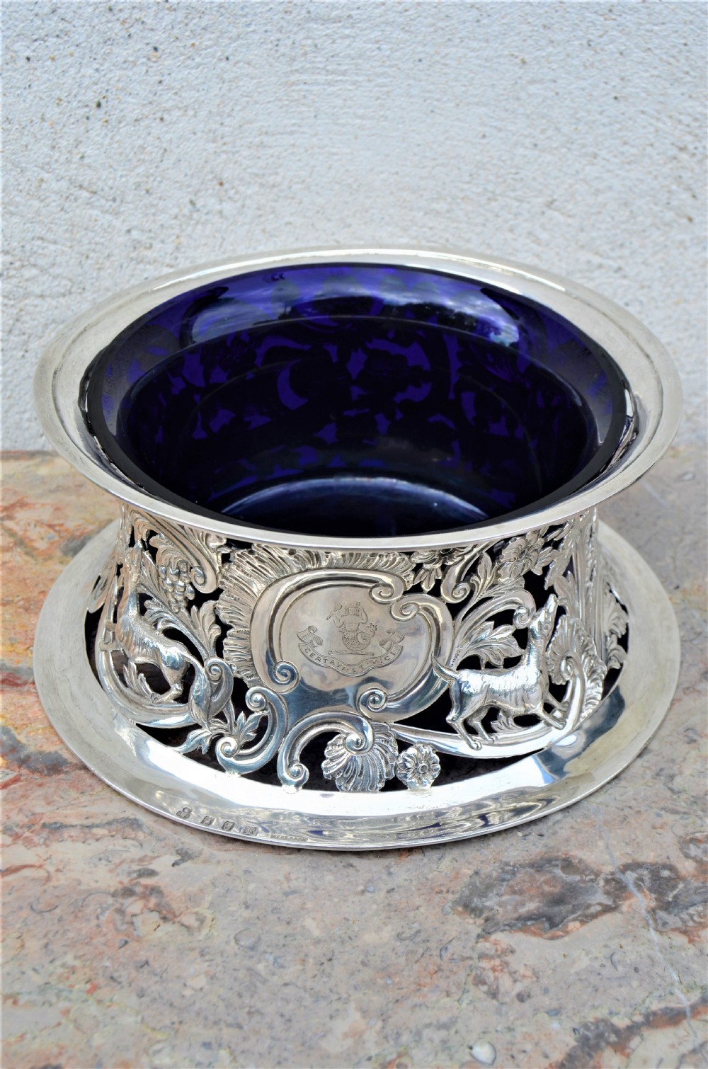 A pierced sterling silver Irish dish ring decorated with repousse animals, scrolls, and an engraved coat of arms, complete with a cobalt blue glass liner. View VI