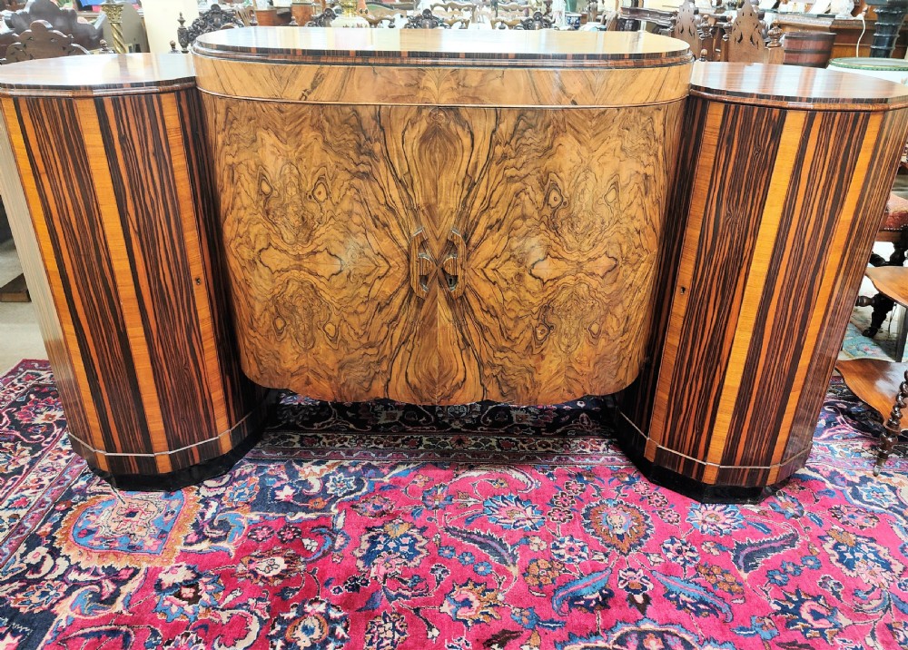 A French Art Deco eleven-piece dining suite comprising an oval dining table, matching high-back chairs, and sideboards featuring heavily figured calamander and macassar ebony veneers. View II