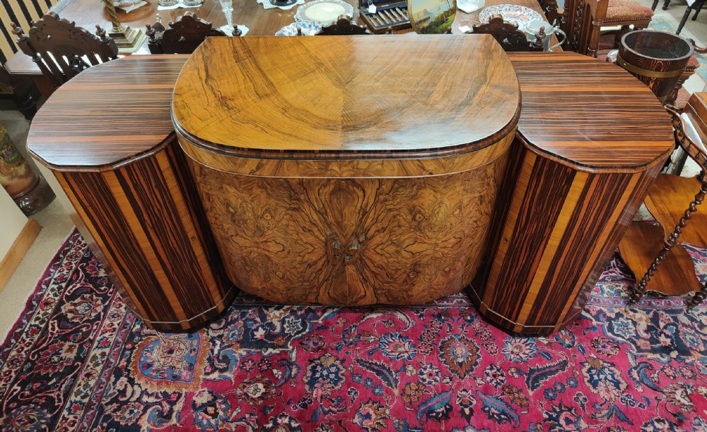 A French Art Deco eleven-piece dining suite comprising an oval dining table, matching high-back chairs, and sideboards featuring heavily figured calamander and macassar ebony veneers. View III