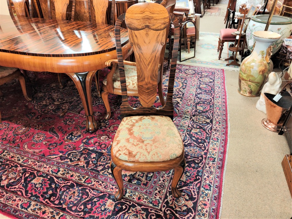 A French Art Deco eleven-piece dining suite comprising an oval dining table, matching high-back chairs, and sideboards featuring heavily figured calamander and macassar ebony veneers. View VIII
